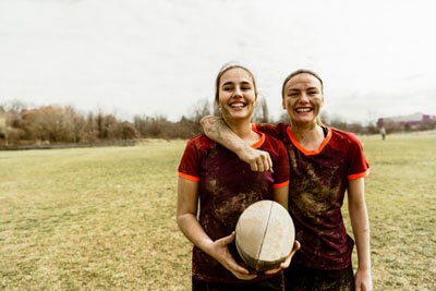 Two girls holding a rugby ball